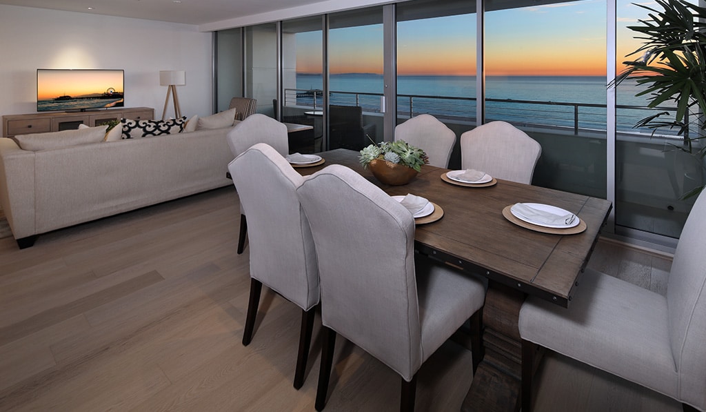 Furnished living room overlooks ocean sunset